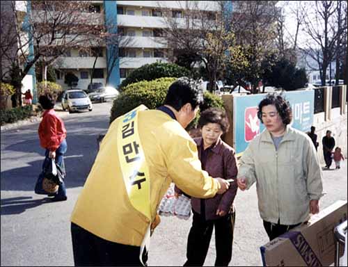 거리에서 유권자들을 만나 인사하고 있는 김만수 후보 